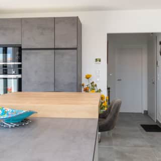 Cuisine moderne en gris d'une maison neuve, alliant élégance et fonctionnalité.