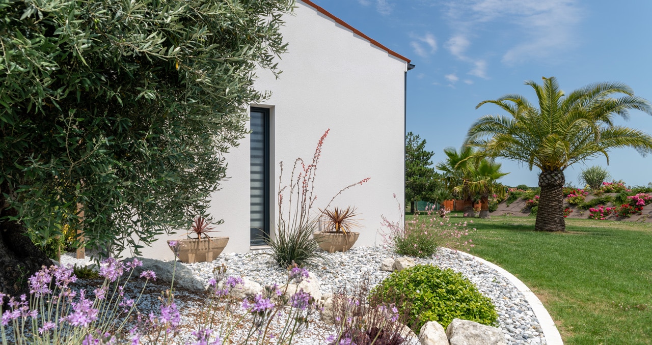 Extérieur d'une maison neuve de 139 m² à Saint-Sulpice-de-Royan, avec un enduit blanc et trois chambres, dont une suite parentale.