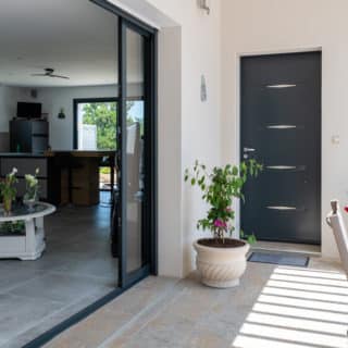 Ouverture de la baie vitrée d'une maison à Saint-Sulpice-de-Royan, offrant une vue sur l'extérieur.