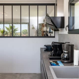 Verrière dans la cuisine d'une maison neuve en Charente-Maritime, apportant lumière naturelle et style