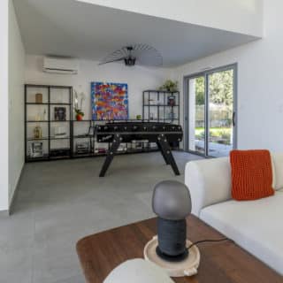 Salle de jeux avec baby-foot dans une maison familiale contemporaine construite aux Sables d’Olonne en Vendée