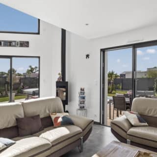 Salon moderne et chaleureux dans une maison contemporaine en Vendée, pensé pour le confort et la lumière naturelle.