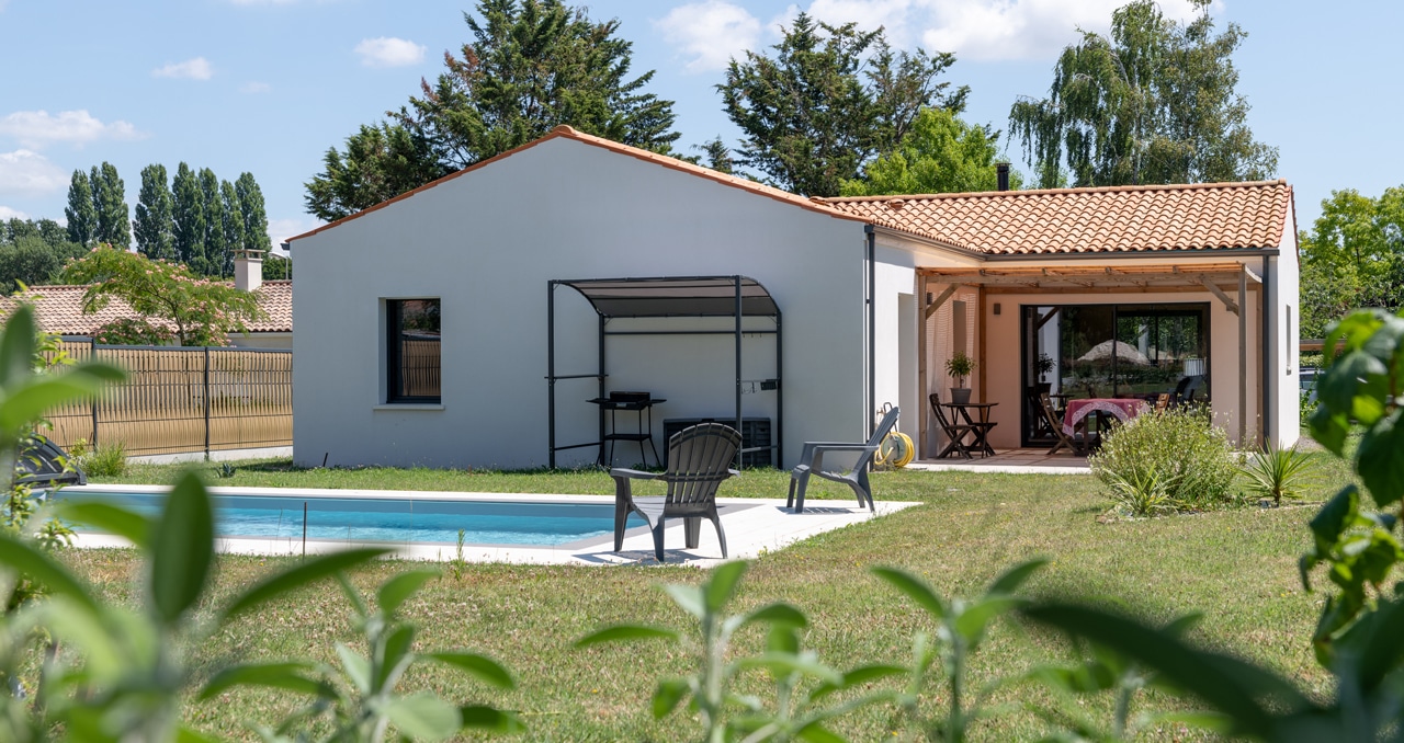 Architecture traditionnelle et tuiles en toiture pour cette maison neuve à Saint-Romain-de-Benet (17). Fonctionnelle avec 3 chambres, 2 salles de bain.