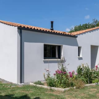Vue d’ensemble d’une maison neuve à Saint-Romain-de-Benet (17), 3 chambres et 2 salles de bain. Tuiles en toiture et style intemporel.