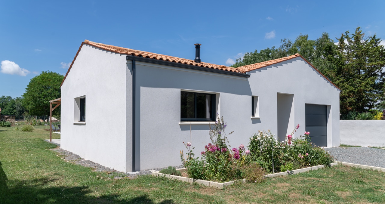 Vue d’ensemble d’une maison neuve à Saint-Romain-de-Benet (17), 3 chambres et 2 salles de bain. Tuiles en toiture et style intemporel.