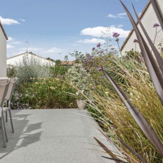 Jardin et terrasse de la maison de 83 m² à Sainte-Flaive-des-Loups, vue arrière extérieure.