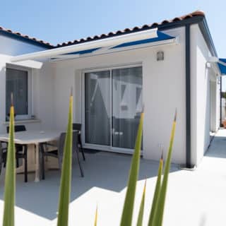 Constructeur de maison à Vaux-sur-Mer – baie vitrée avec terrasse et vue sur le jardin