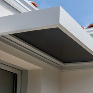 Casquette de porte d’entrée gris clair sur une maison neuve de 99 m² aux Sables-d’Olonne, constructeur de maisons en Vendée.