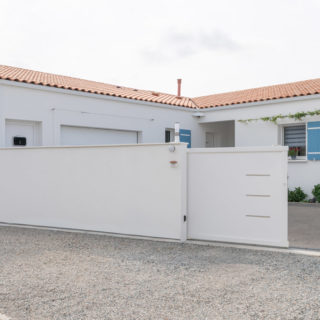 Entrée principale d’une maison plain-pied à Bourgneuf, Charente-Maritime, avec volets bleus