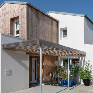 Façade avant d’une maison contemporaine avec bardage bois dans un écoquartier près de La Rochelle