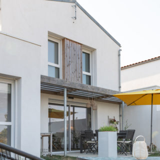 Vue arrière d’une maison neuve avec terrasse et jardin à L’Houmeau