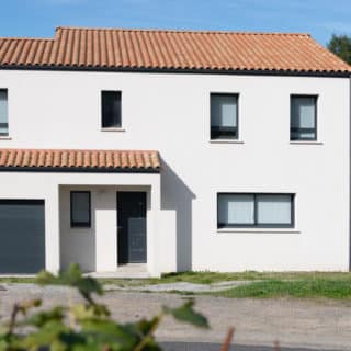 Vue frontale de maison neuve à Thorigny avec enduit ton pierre et tuiles mêlé Atlantique – constructeur maison Thorigny
