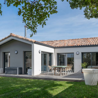 Maison neuve aux Sables-d’Olonne vue côté jardin avec porche et toit cathédrale