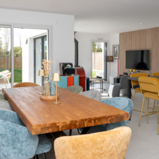 Pièce de vie avec Baie à galandage ALU 3 vantaux 3 rails ouverte sur la terrasse