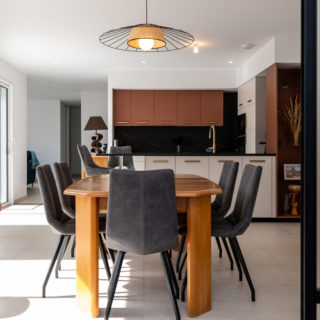 Cuisine séparant le séjour et la salle à manger dans une maison neuve de 120 m²