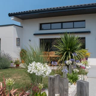 Maison plain-pied style villa avec toiture tuiles noires